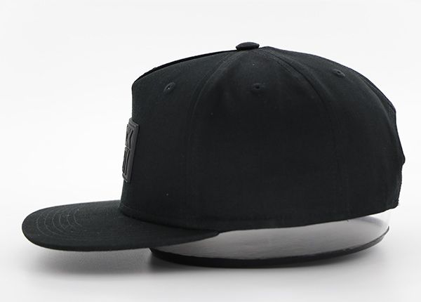 Side of All Black Snapback Hat With Leather Label