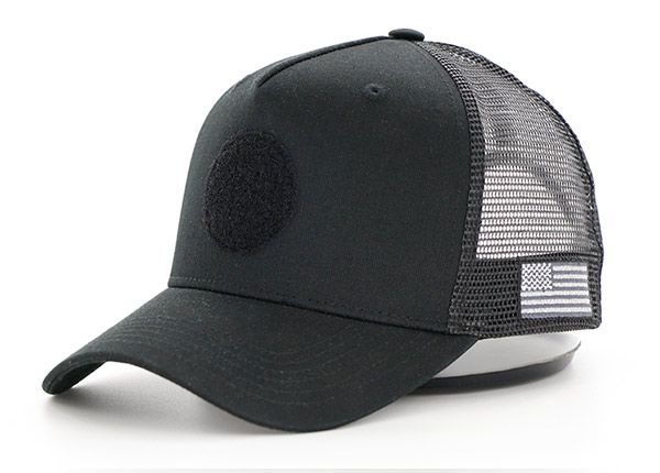 Slant of All Black Trucker Hat With a Black Velcro Logo & a American Flag Logo on Side